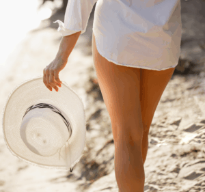 model walking with hat on beach